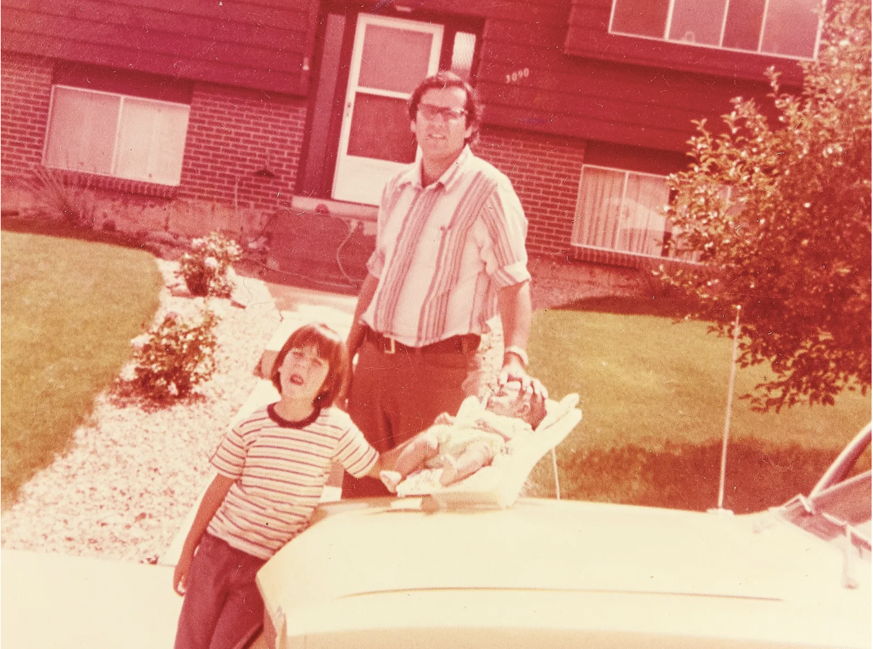 red tone photo of a family next to a car