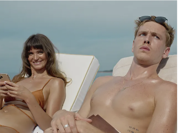 a man and smiling woman laying on sun chairs