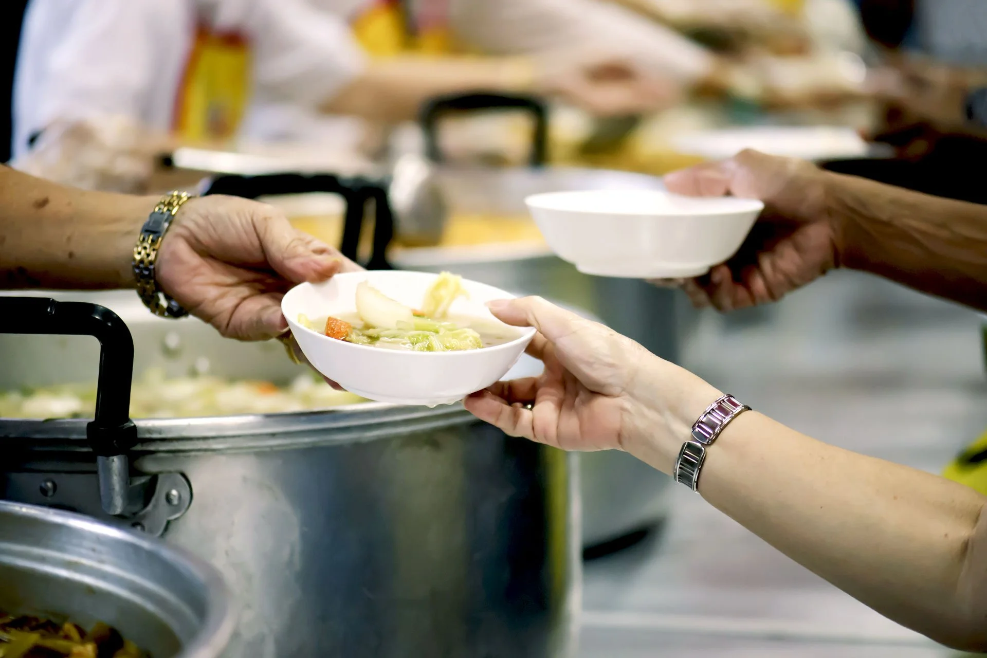 a person handing out food to someone
